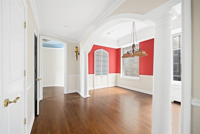 spare room with ornate columns, crown molding, and dark hardwood / wood-style floors