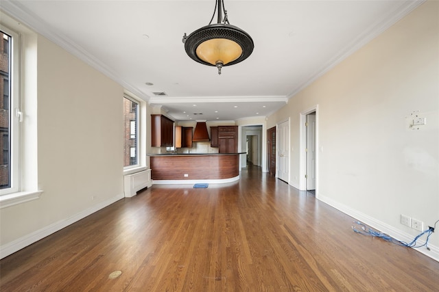 unfurnished living room featuring plenty of natural light, dark hardwood / wood-style flooring, and crown molding