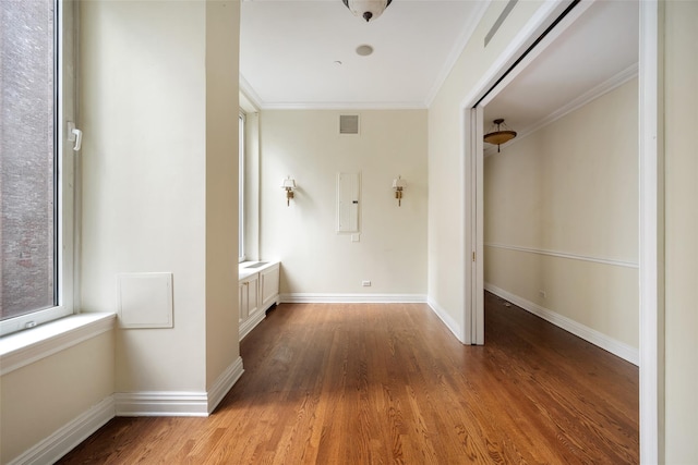 hallway featuring electric panel, hardwood / wood-style flooring, and ornamental molding