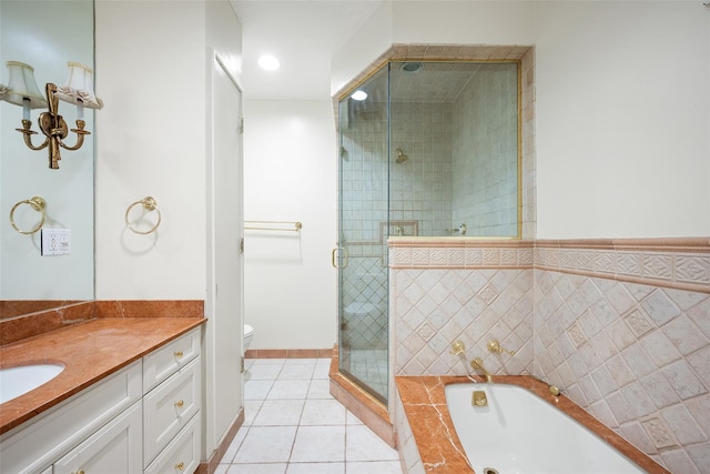 full bathroom featuring tile patterned floors, vanity, tile walls, shower with separate bathtub, and toilet