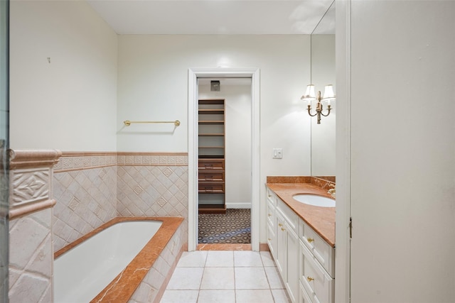 bathroom featuring tile patterned flooring, vanity, and a bath