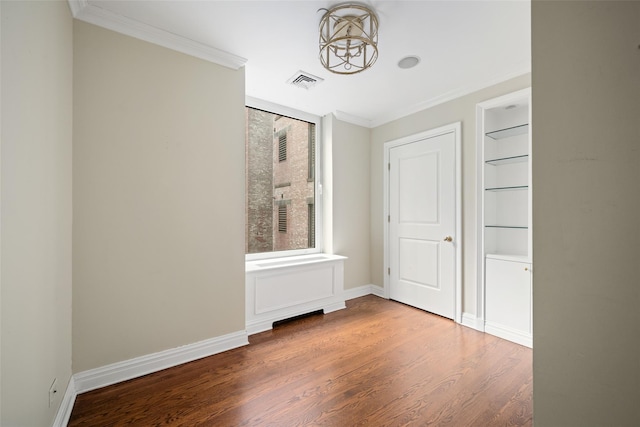 unfurnished bedroom with hardwood / wood-style floors, crown molding, and an inviting chandelier