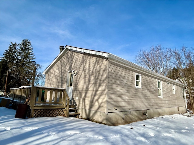 view of snow covered exterior featuring a wooden deck