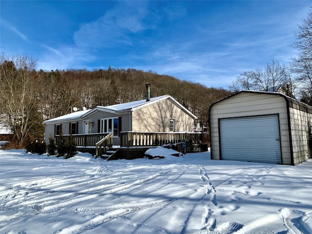 exterior space with a garage, an outdoor structure, and a deck