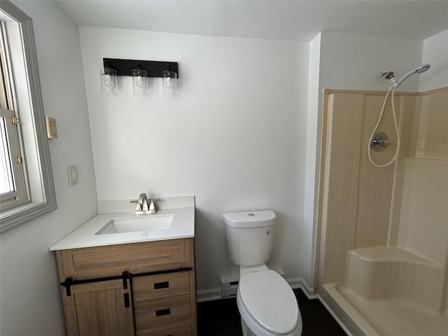 bathroom with vanity, toilet, walk in shower, and a baseboard heating unit