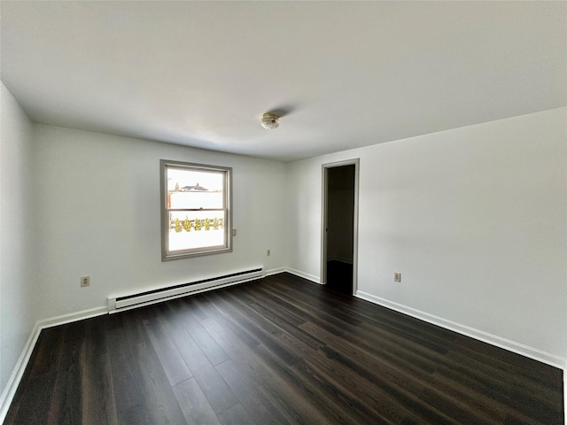 empty room with baseboard heating and dark wood-type flooring