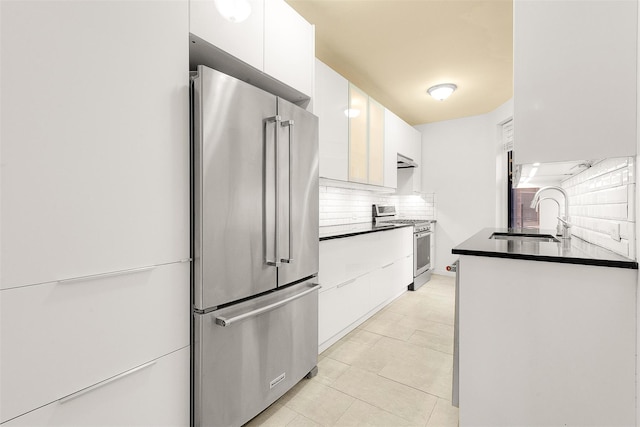 kitchen featuring white cabinets, sink, appliances with stainless steel finishes, tasteful backsplash, and extractor fan