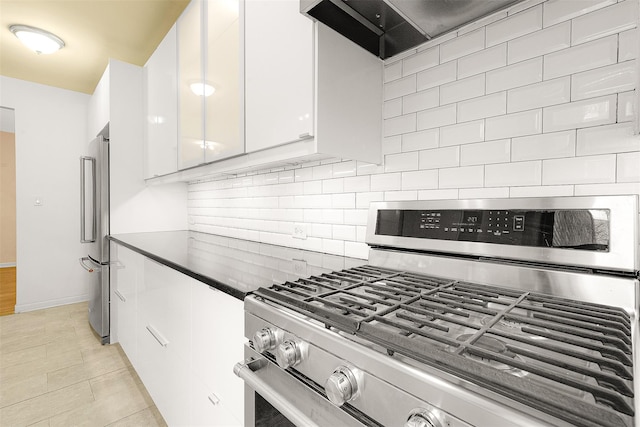 kitchen with tasteful backsplash, custom range hood, stainless steel appliances, light tile patterned floors, and white cabinets