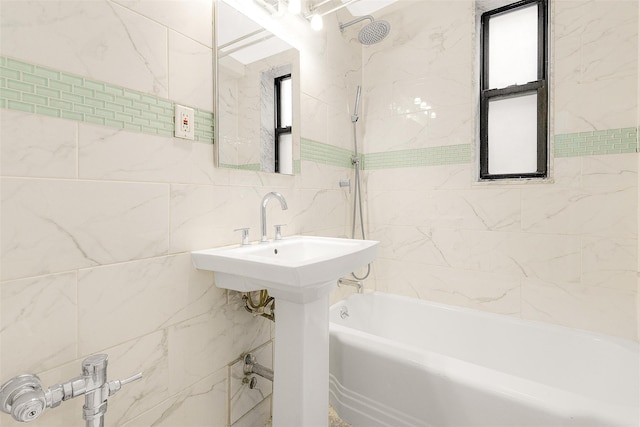 bathroom with tiled shower / bath combo and tile walls