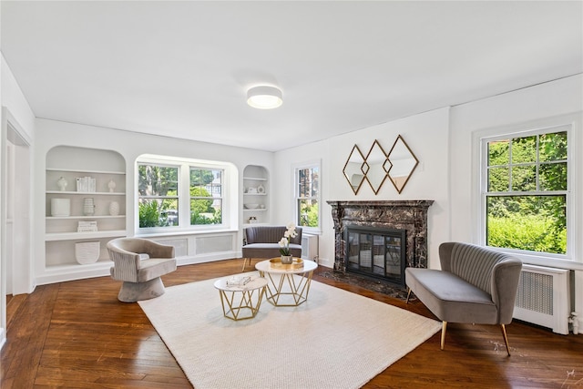109 Argyll Ave, New Rochelle, NY 10804 - living room featuring radiator, built in shelves, plenty of natural light, and a high end fireplace