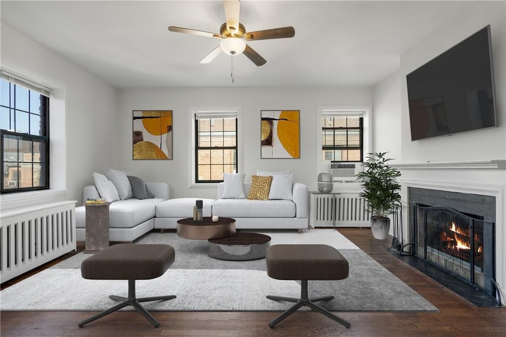 living room with radiator, a healthy amount of sunlight, and ceiling fan