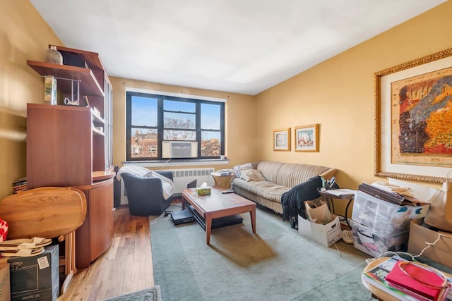 living room with light hardwood / wood-style floors, radiator, and cooling unit