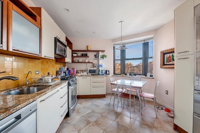 kitchen featuring white cabinets, sink, hanging light fixtures, decorative backsplash, and stainless steel appliances