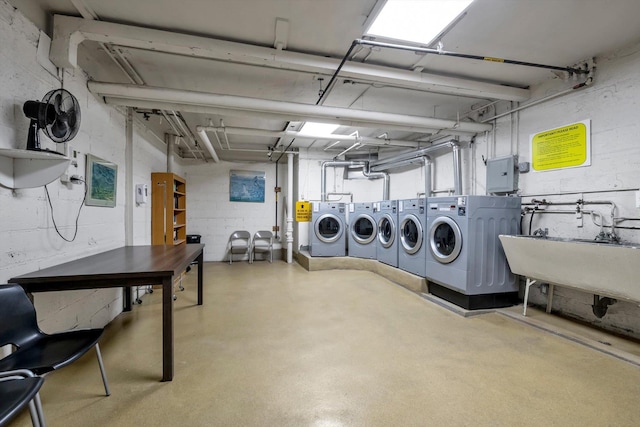 clothes washing area featuring washer and clothes dryer and sink