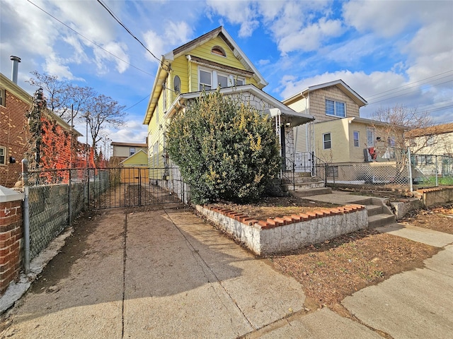 129-06 131st St, South Ozone Park, NY 11420 - view of front facade with a gate and concrete driveway