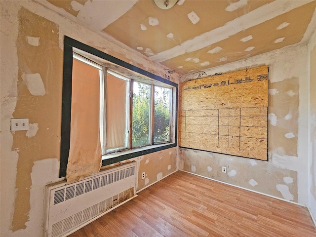 129-06 131st St, South Ozone Park, NY 11420 - unfurnished room featuring radiator and light wood finished floors