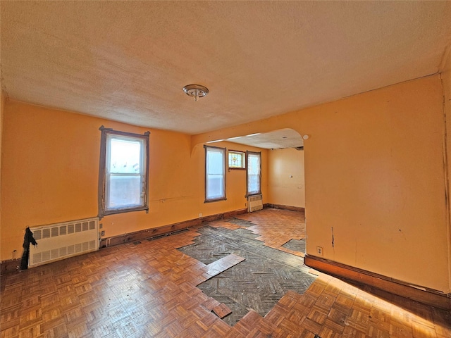 129-06 131st St, South Ozone Park, NY 11420 - unfurnished room with radiator heating unit and a textured ceiling