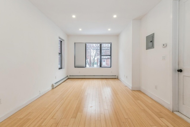 unfurnished room featuring electric panel and light hardwood / wood-style floors