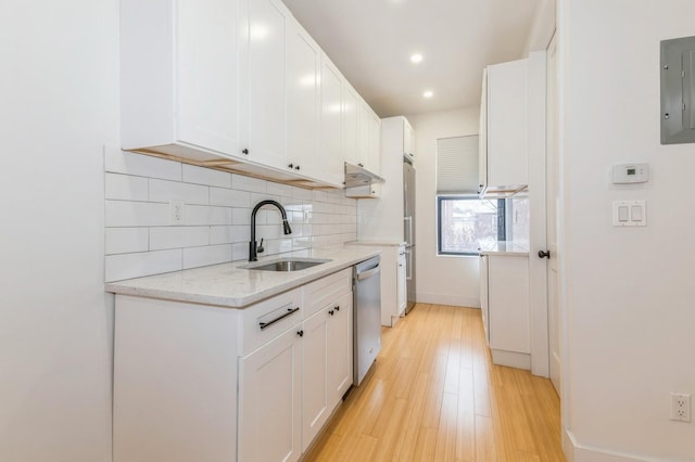 kitchen with light wood-type flooring, stainless steel appliances, sink, electric panel, and white cabinetry