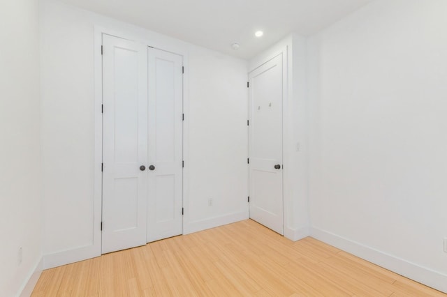 unfurnished bedroom featuring hardwood / wood-style floors and a closet