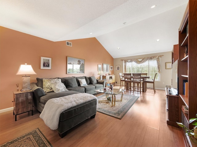 living room featuring hardwood / wood-style flooring and vaulted ceiling