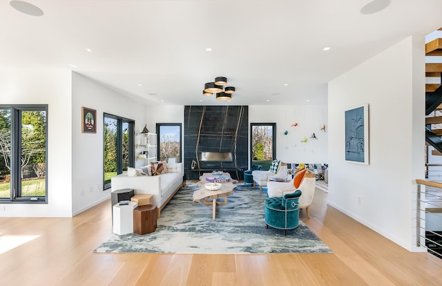 living room featuring a high end fireplace and light wood-type flooring