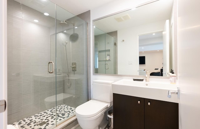 bathroom with vanity, toilet, and a shower with shower door