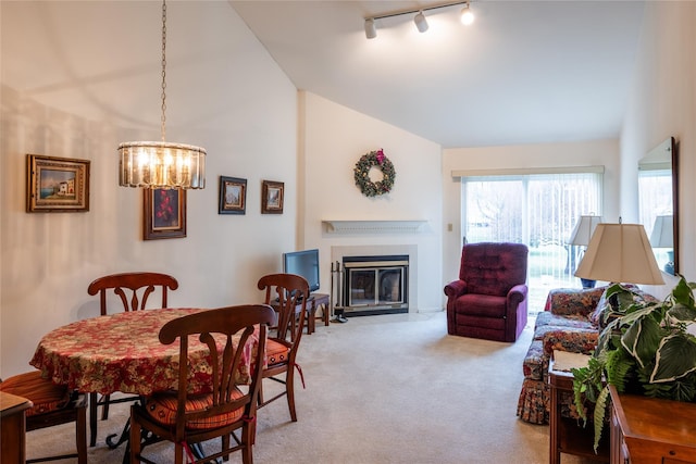 dining space with a notable chandelier, lofted ceiling, light carpet, and track lighting