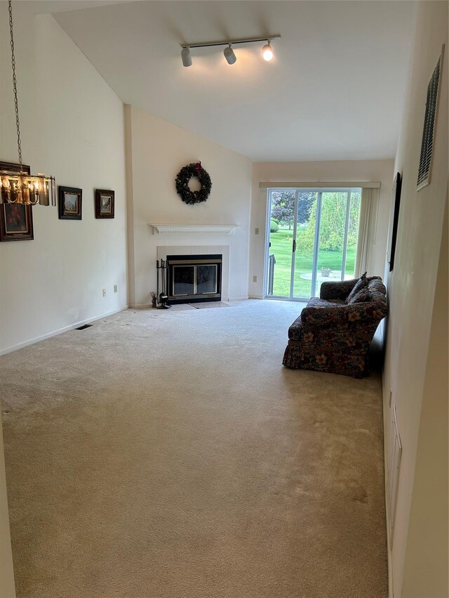 2555 Youngs Unit 7D, Southold, NY 11971 - living area with carpet, track lighting, vaulted ceiling, a fireplace with flush hearth, and a chandelier