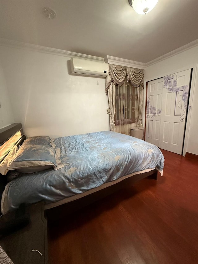 bedroom with dark wood-type flooring, an AC wall unit, a closet, and crown molding