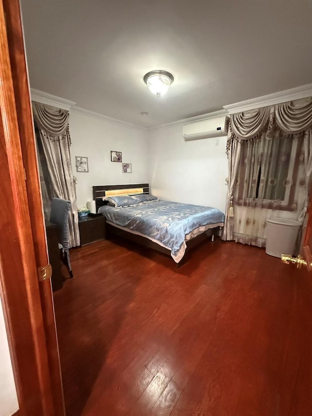 unfurnished bedroom with a wall unit AC, wood-type flooring, and ornamental molding