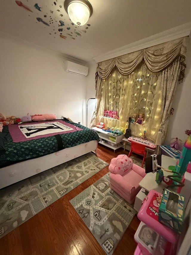 bedroom with a wall unit AC and wood-type flooring