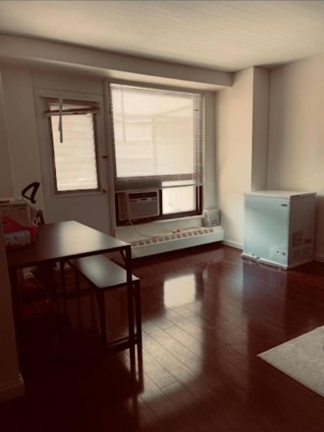 interior space with cooling unit, dark wood-type flooring, and a baseboard radiator