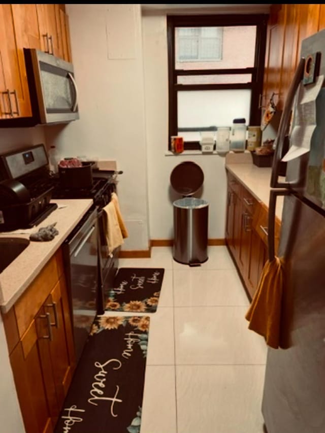 kitchen with light tile patterned floors and appliances with stainless steel finishes