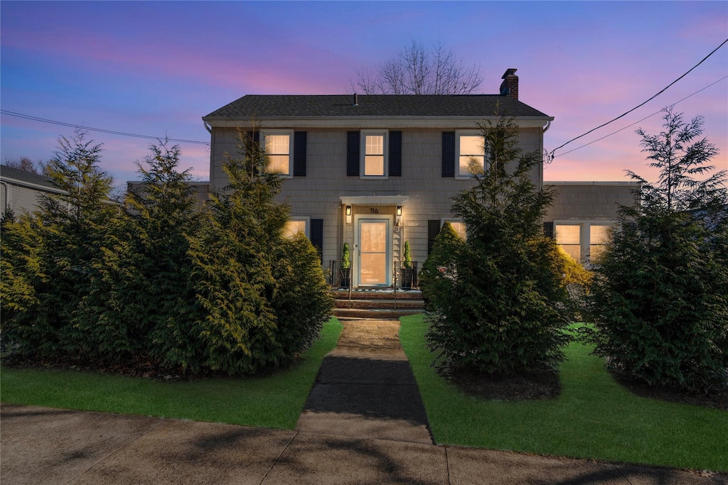 colonial home featuring a lawn