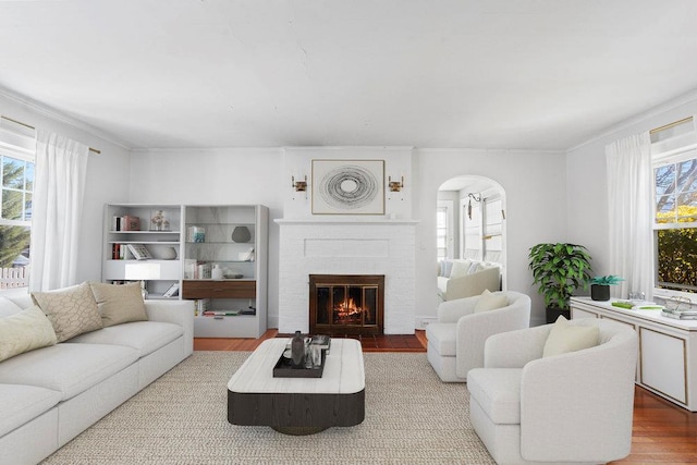 living room featuring crown molding, a fireplace, and hardwood / wood-style floors