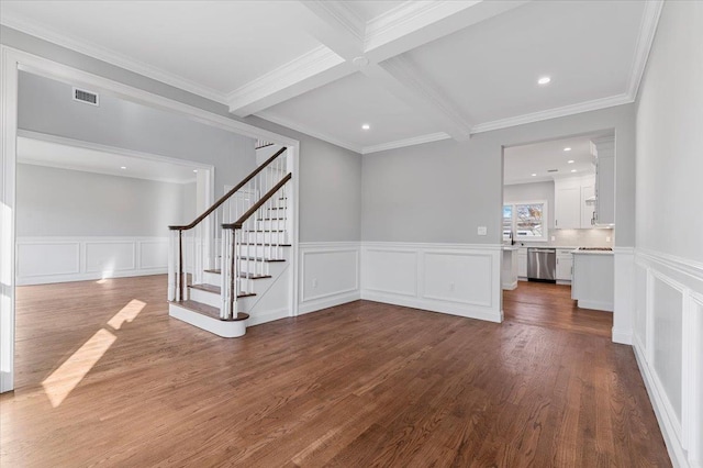 unfurnished living room featuring hardwood / wood-style flooring, beamed ceiling, coffered ceiling, and ornamental molding