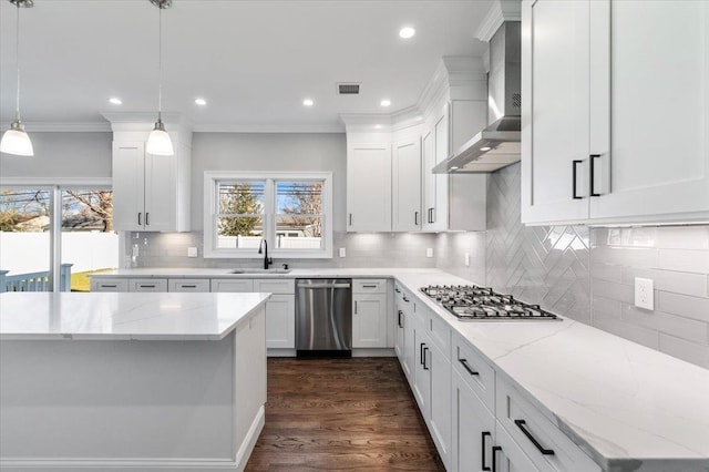 kitchen with white cabinetry, wall chimney range hood, hanging light fixtures, and appliances with stainless steel finishes