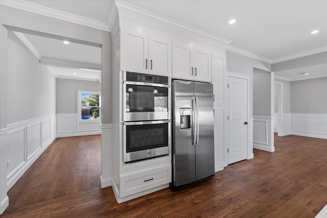 kitchen with dark wood-type flooring, white cabinets, ornamental molding, and appliances with stainless steel finishes