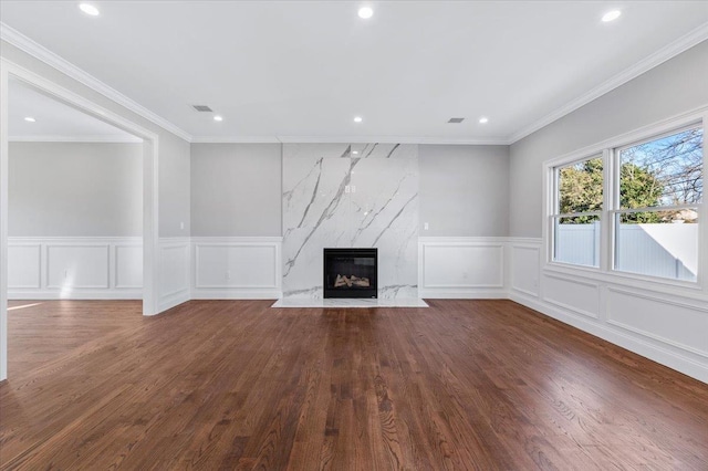 unfurnished living room featuring dark hardwood / wood-style floors, crown molding, and a fireplace