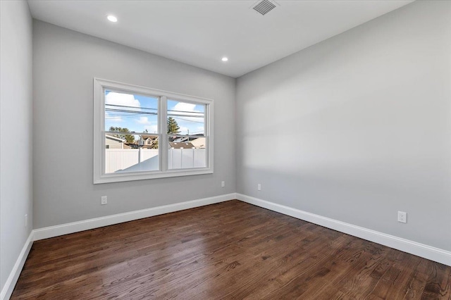 empty room with dark hardwood / wood-style flooring