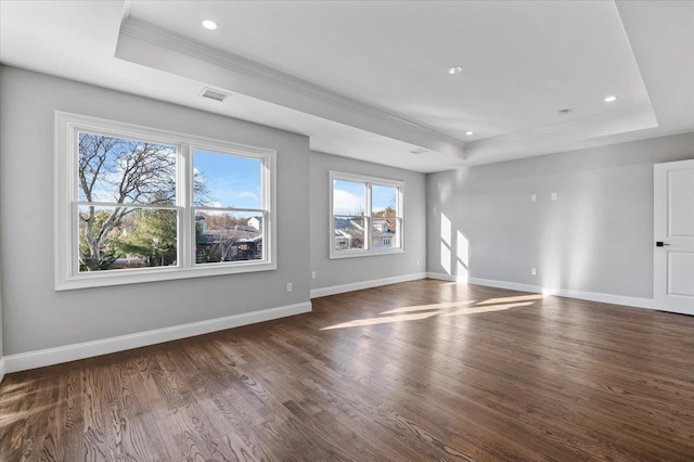 unfurnished living room featuring a tray ceiling and dark hardwood / wood-style floors