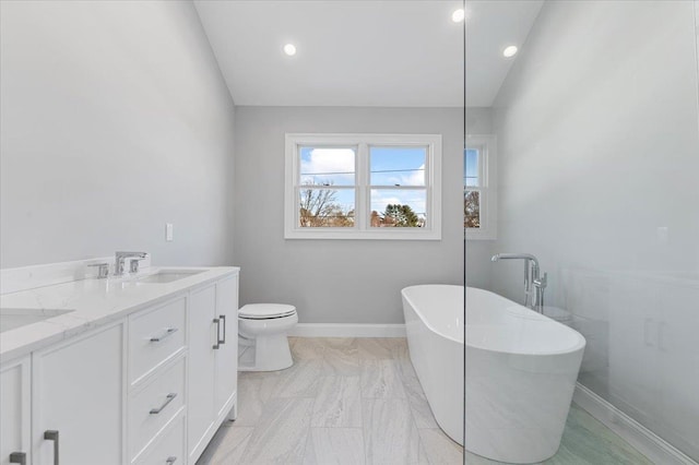 bathroom featuring a washtub, toilet, lofted ceiling, and vanity