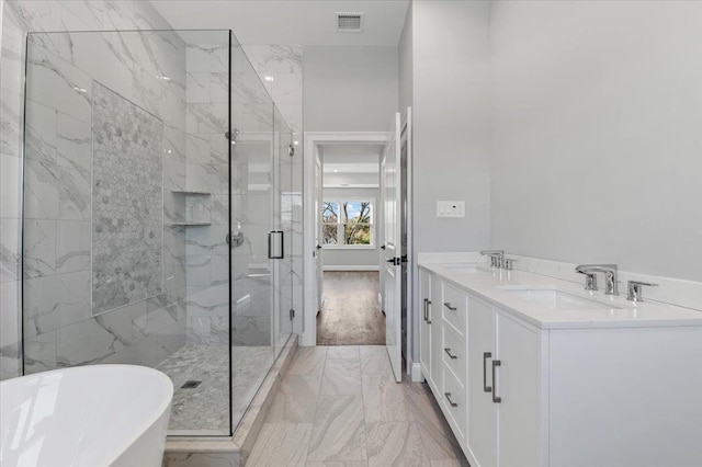 bathroom with vanity and shower with separate bathtub