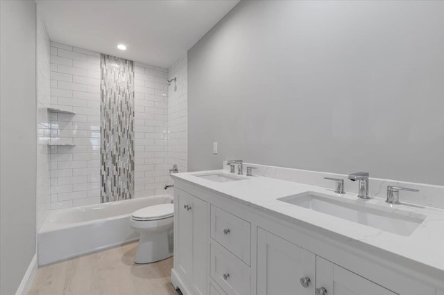 full bathroom with vanity, hardwood / wood-style flooring, toilet, and tiled shower / bath