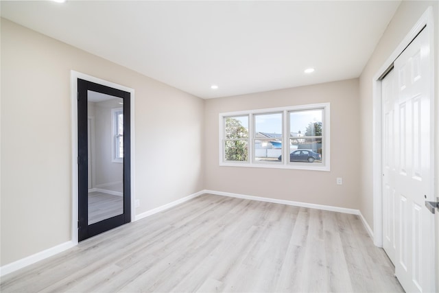 unfurnished bedroom with light hardwood / wood-style floors and multiple windows