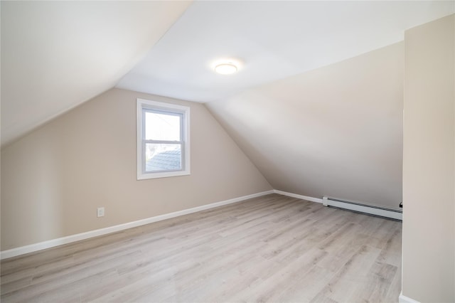 additional living space with light hardwood / wood-style floors, lofted ceiling, and baseboard heating