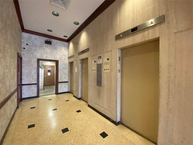 hallway featuring a towering ceiling, elevator, and ornamental molding