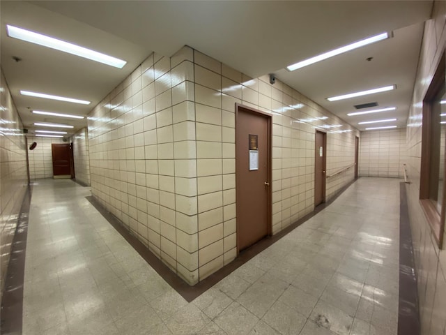 hallway featuring tile walls