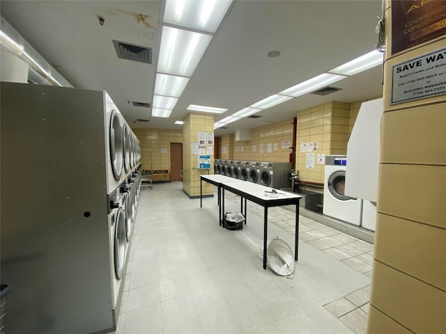 kitchen with stacked washing maching and dryer and washing machine and clothes dryer